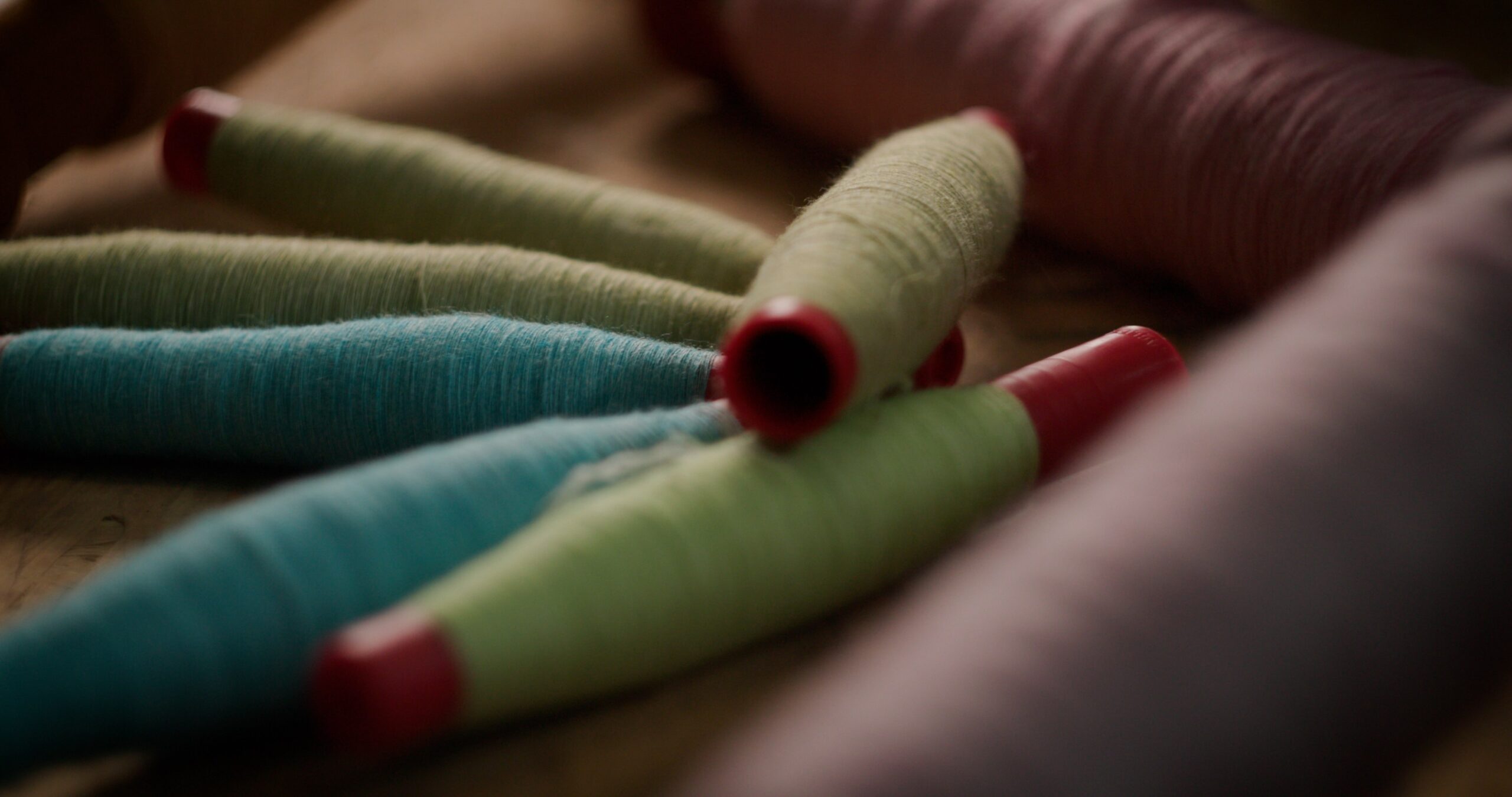 coloured yarns on bobbins from trials